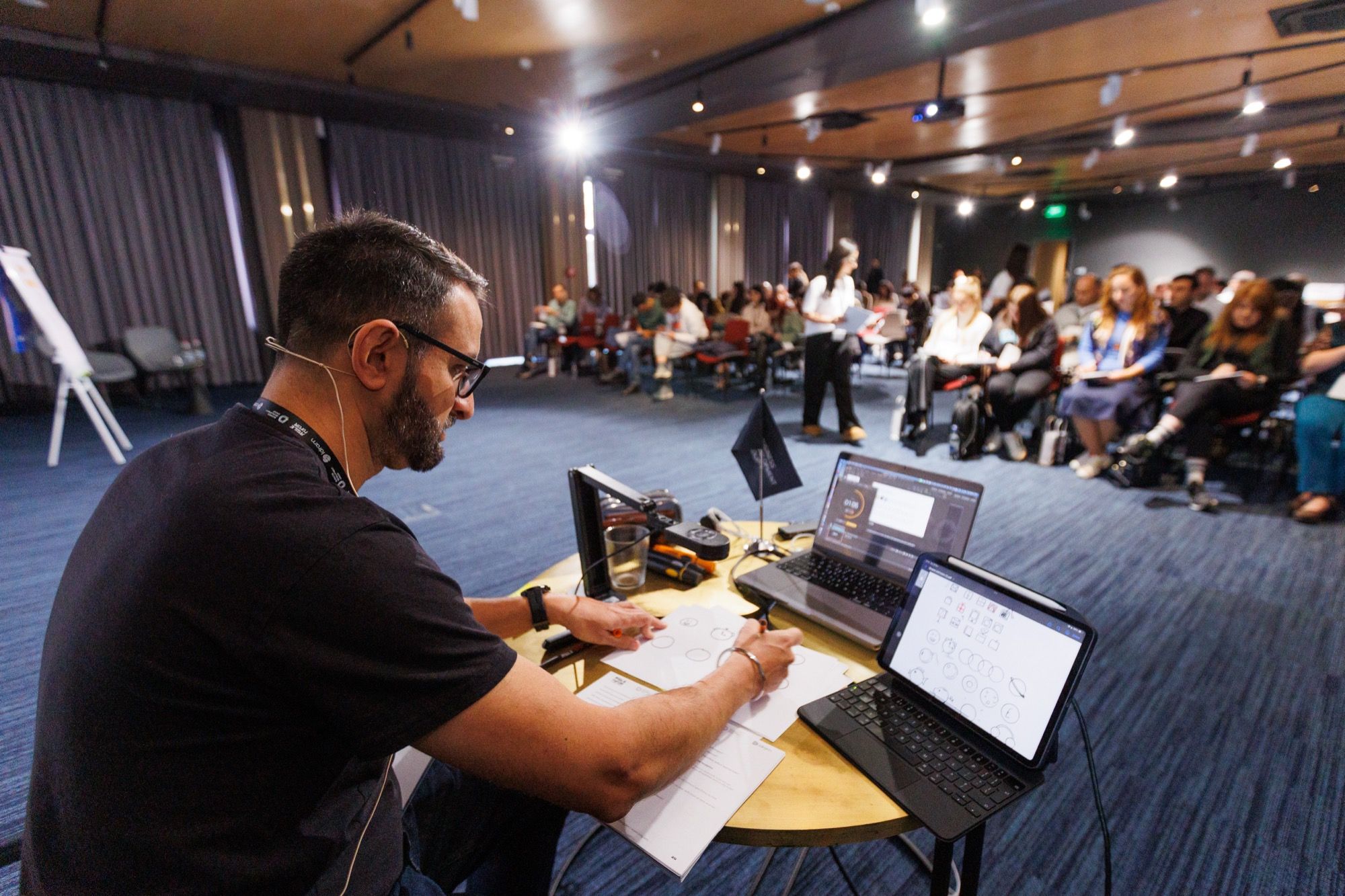 Paddy sketching on an iPad while an audience watches
